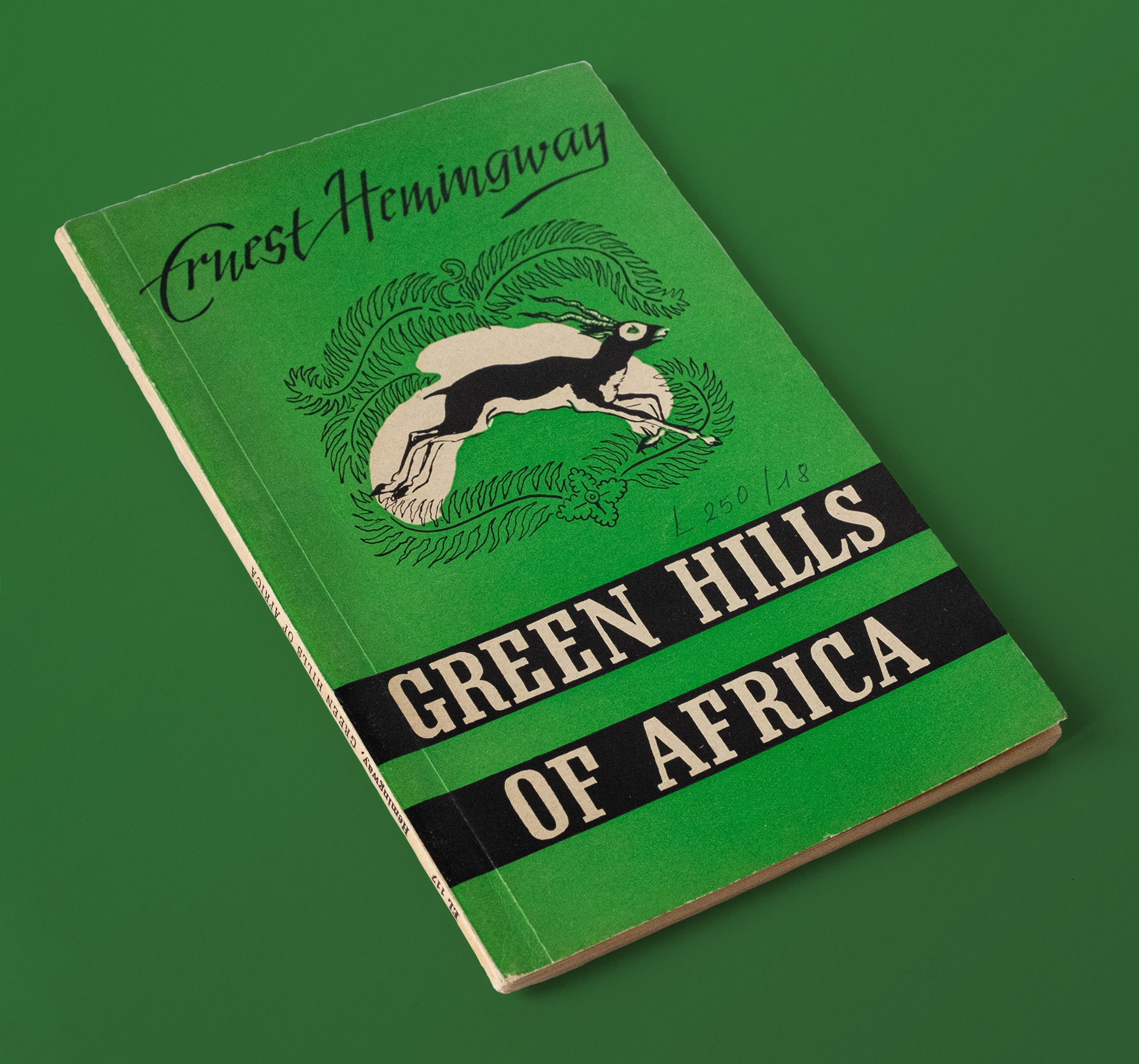 Grün-weißes Buch, dass ein Antilope auf der Vorderseite zeigt, mit dem Titel "Green Hills Of Africa"