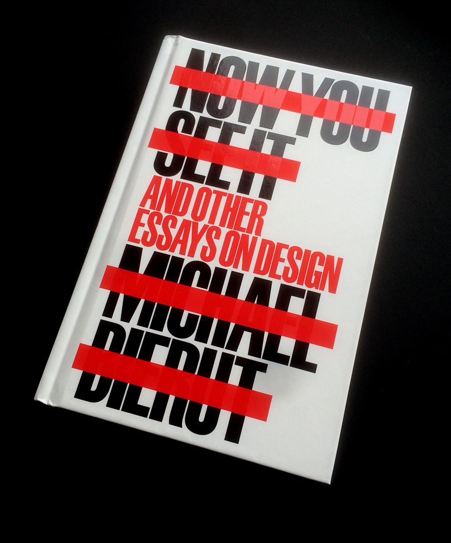 Buchcover von Michael Bierut, der Titel "Now You See It and Other Essays on Design" ist in großer, serifenlosen Schrift gesetzt. Die Hälfte des Textes ist mit einem roten Strich durchgestrichen, wodurch der Text jedoch eher gelesen wird.